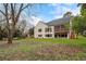 Back exterior of home with a large backyard, mature trees, a screened porch, and deck at 4895 Lansbury Dr, Atlanta, GA 30342