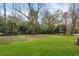 Manicured backyard with lush grass, mature trees, and plenty of space for outdoor activities at 4895 Lansbury Dr, Atlanta, GA 30342