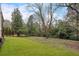 Exterior shot of a large backyard with a partial view of the home and many mature trees at 4895 Lansbury Dr, Atlanta, GA 30342