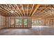 Unfinished basement with exposed wood beams, insulation, concrete floors, and large windows at 4895 Lansbury Dr, Atlanta, GA 30342