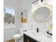 Stylish bathroom with a round mirror, white countertops, and modern fixtures at 4895 Lansbury Dr, Atlanta, GA 30342