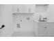 Clean laundry room with white cabinets, quartz countertops, chrome fixtures, and hexagonal tile flooring at 4895 Lansbury Dr, Atlanta, GA 30342