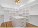 Large walk-in closet with custom shelving, storage drawers, island, and hardwood flooring at 4895 Lansbury Dr, Atlanta, GA 30342