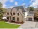 Charming brick home boasts manicured landscaping, a spacious driveway, and attached two-car garage at 4895 Lansbury Dr, Atlanta, GA 30342