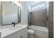 Well lit bathroom features a tub, large mirror, and white sink with gray wall tiling at 158 South Village Ave, Holly Springs, GA 30115