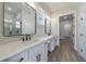 Bathroom features a double sink vanity with framed mirrors and a door leading to the marble tile shower at 158 South Village Ave, Holly Springs, GA 30115
