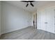 An airy bedroom with light gray flooring features a ceiling fan and white paneled doors at 158 South Village Ave, Holly Springs, GA 30115