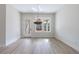 Bright dining room with wood floors, modern chandelier, and large window offering natural light at 158 South Village Ave, Holly Springs, GA 30115