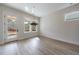 Dining room featuring light wood floors with modern light fixtures and a large window at 158 South Village Ave, Holly Springs, GA 30115