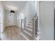 Bright entrance hallway with wood staircase and modern lighting at 158 South Village Ave, Holly Springs, GA 30115
