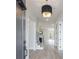 Bright hallway with hardwood floors, modern lighting, and staircase at 158 South Village Ave, Holly Springs, GA 30115