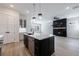 View of the open kitchen with a large island, stainless steel appliances and a fireplace at 158 South Village Ave, Holly Springs, GA 30115