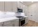 The kitchen features stainless steel appliances, white countertops, and modern cabinetry at 158 South Village Ave, Holly Springs, GA 30115