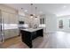 Modern kitchen with stainless appliances, gray cabinets, large island and hardwood floors at 158 South Village Ave, Holly Springs, GA 30115