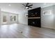 Spacious living room with a fireplace and light wood floors with a view of the exterior at 158 South Village Ave, Holly Springs, GA 30115