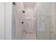 A modern shower with marble tile, rainfall shower head, and frameless glass enclosure at 158 South Village Ave, Holly Springs, GA 30115