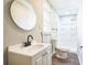 Updated bathroom with a white vanity, round mirror, and a walk-in shower with a white tile surround at 5063 White Sw Blvd, Mableton, GA 30126