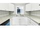 Well-organized kitchen with granite countertops, white cabinets, and a stainless steel sink beneath the window at 5063 White Sw Blvd, Mableton, GA 30126