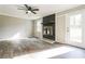 Bright living room with a stone fireplace, ceiling fan, wood-look flooring, and a door to the backyard at 5063 White Sw Blvd, Mableton, GA 30126
