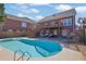 A view of the backyard with an in-ground pool, a two-story brick house and upper deck at 2020 Stockton Walk Ln, Snellville, GA 30078