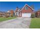 Charming two-story brick home with a well-manicured lawn and a paved driveway at 2020 Stockton Walk Ln, Snellville, GA 30078