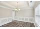 Inviting dining room with tray ceiling, classic chandelier, wainscoting and great natural light at 114 Highgrove Pl, Mcdonough, GA 30253