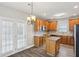 Bright eat-in kitchen with wooden cabinets, an island, and glass door access to the yard at 114 Highgrove Pl, Mcdonough, GA 30253