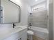 Bathroom featuring a shower-tub, vanity, modern fixtures, and neutral tiling at 160 South Village Ave, Holly Springs, GA 30115