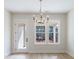 Bright dining room with a chandelier and large windows overlooking the backyard at 160 South Village Ave, Holly Springs, GA 30115