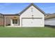Back of house with a patio, a two-car garage and a lawn at 160 South Village Ave, Holly Springs, GA 30115