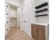 Hallway featuring a built-in cabinet with floating shelves and access to the laundry room at 160 South Village Ave, Holly Springs, GA 30115