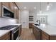 Modern kitchen featuring stainless steel appliances, white backsplash, gas range and quartz countertops at 160 South Village Ave, Holly Springs, GA 30115