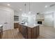 Open concept kitchen with white countertops, stainless steel appliances, a center island and a stone fireplace at 160 South Village Ave, Holly Springs, GA 30115