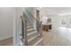 Staircase leading to the open-concept kitchen with a kitchen island and modern features at 160 South Village Ave, Holly Springs, GA 30115