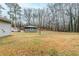 Spacious backyard featuring lush trees, offering privacy and shade and a detached building at 6120 Gwendoline Dr, Atlanta, GA 30349