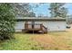 Backyard featuring a wooden deck that enhances the outdoor living space, surrounded by mature trees and greenery at 6120 Gwendoline Dr, Atlanta, GA 30349