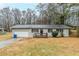 Charming single-story home with a light grey painted brick, a front porch, a well maintained lawn, and attached garage at 6120 Gwendoline Dr, Atlanta, GA 30349