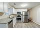 Modern kitchen boasts stainless steel appliances, white cabinets, granite countertops, and sleek vinyl flooring at 6120 Gwendoline Dr, Atlanta, GA 30349