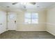 Bright living room featuring neutral carpet, a ceiling fan, a window, and a white front door for a clean, inviting space at 6120 Gwendoline Dr, Atlanta, GA 30349