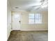 Well-lit living room with a window, neutral carpet, a ceiling fan, and a front door, creating a comfortable and inviting space at 6120 Gwendoline Dr, Atlanta, GA 30349