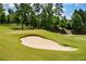 Golf course bunker with a sandy trap and perfectly manicured green surroundings for golf enthusiasts at 411 Ridgeway Ln, Canton, GA 30114