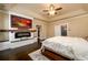 Bright main bedroom with an entertainment center, fire place, and a ceiling fan at 411 Ridgeway Ln, Canton, GA 30114