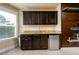 A wet bar area featuring a stainless steel mini fridge, granite countertop, and dark cabinetry at 411 Ridgeway Ln, Canton, GA 30114