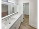 Modern bathroom featuring a large mirror and marble countertop with updated cabinets and wood plank flooring at 4409 Idlewood Ln, Tucker, GA 30084