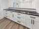 Close-up of stylish built-in counter area with sleek black countertop and white cabinets at 4409 Idlewood Ln, Tucker, GA 30084
