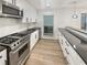 Well-lit kitchen featuring stainless steel appliances, white cabinets, and dark countertops at 4409 Idlewood Ln, Tucker, GA 30084