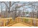 Backyard deck and stairs overlooking a wooded backyard with mature trees and neighbor's home at 4055 Covey Ln, Douglasville, GA 30135