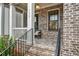 Charming brick porch with stylish railing and a black metal bench that enhances the curb appeal of the home at 578 Brashy Street, Woodstock, GA 30188