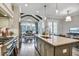 Modern kitchen featuring a large island with seating and stainless appliances open to living and dining areas at 578 Brashy Street, Woodstock, GA 30188