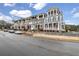 View of modern townhomes with gray exteriors and well-manicured landscaping, cars parked on the street, and a cloudy sky at 578 Brashy Street, Woodstock, GA 30188